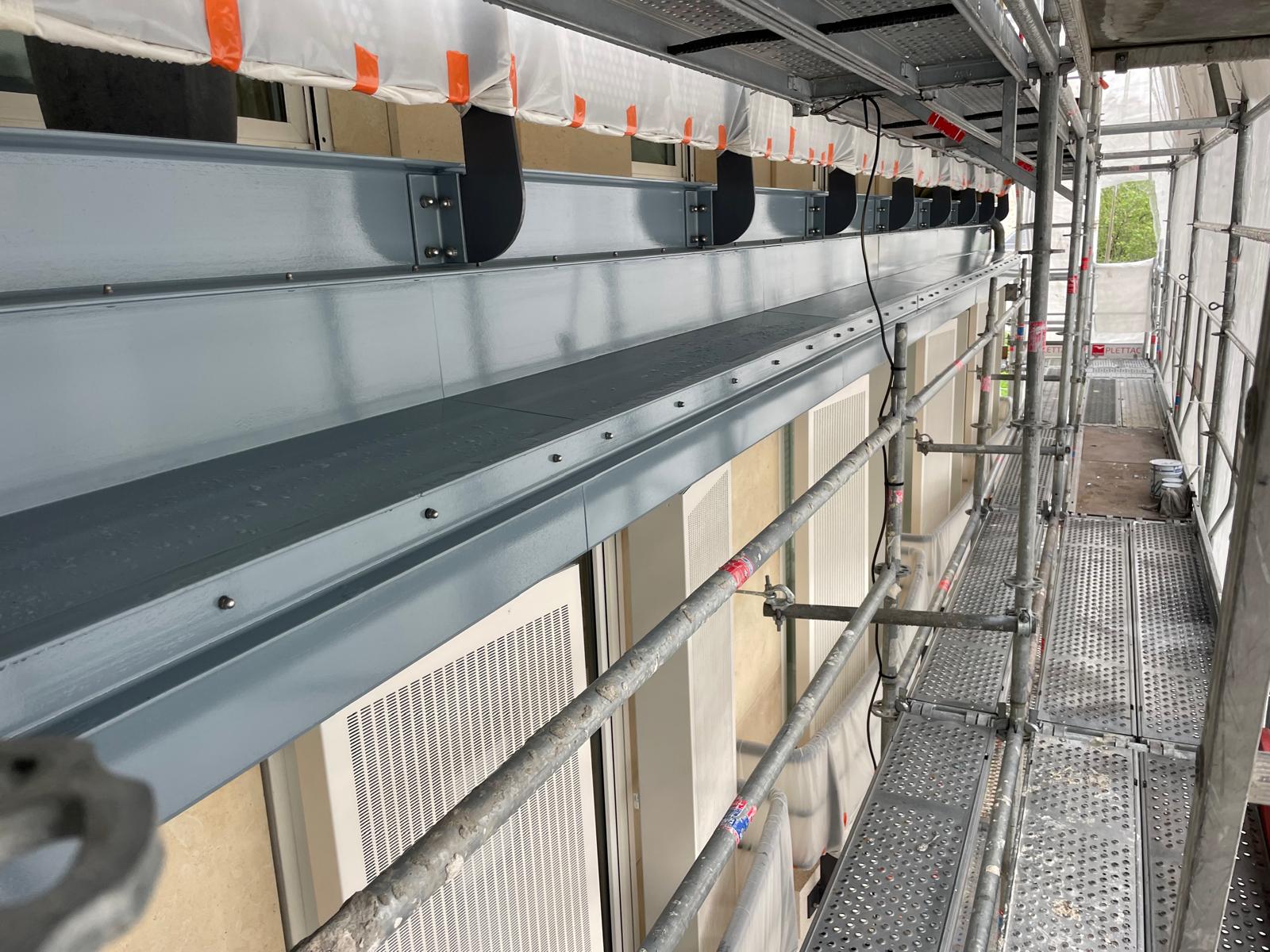 Travaux de façade le long des fenêtres et de la plateforme d'échafaudage