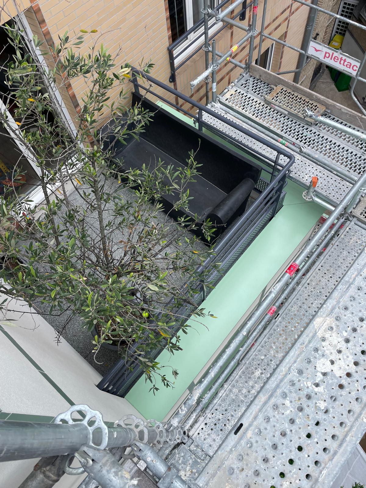 Vue plongeante sur la cour et les éléments verts de la façade en chantier