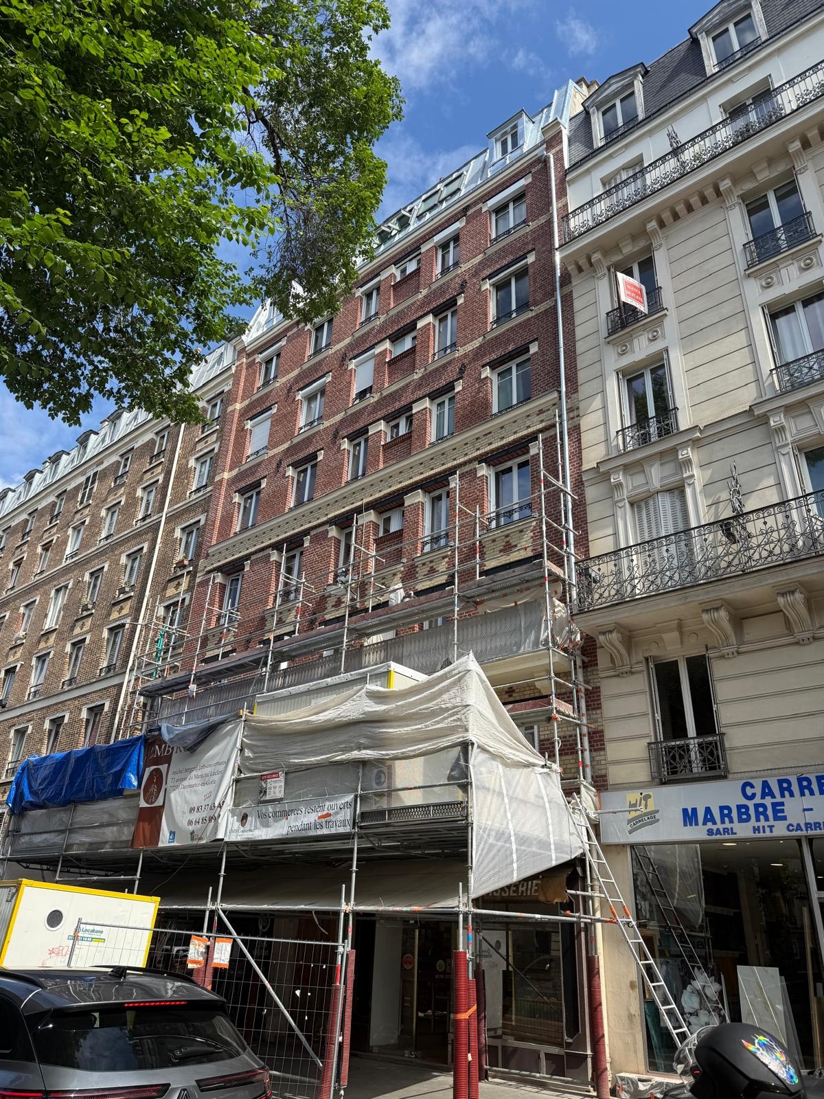 Vue d'ensemble d'un immeuble ancien et de sa façade sous échafaudage