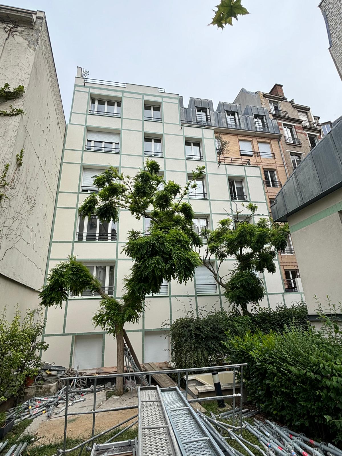Façade rénovée de l'immeuble donnant sur une cour arborée
